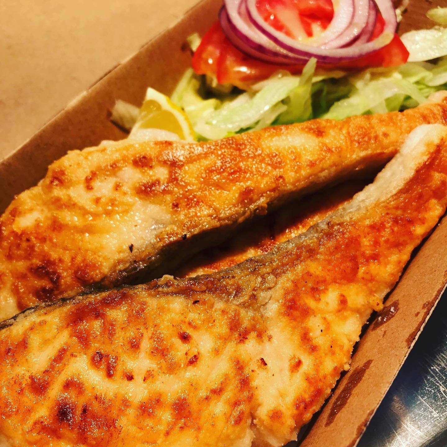 Fish with salad in a takeaway box