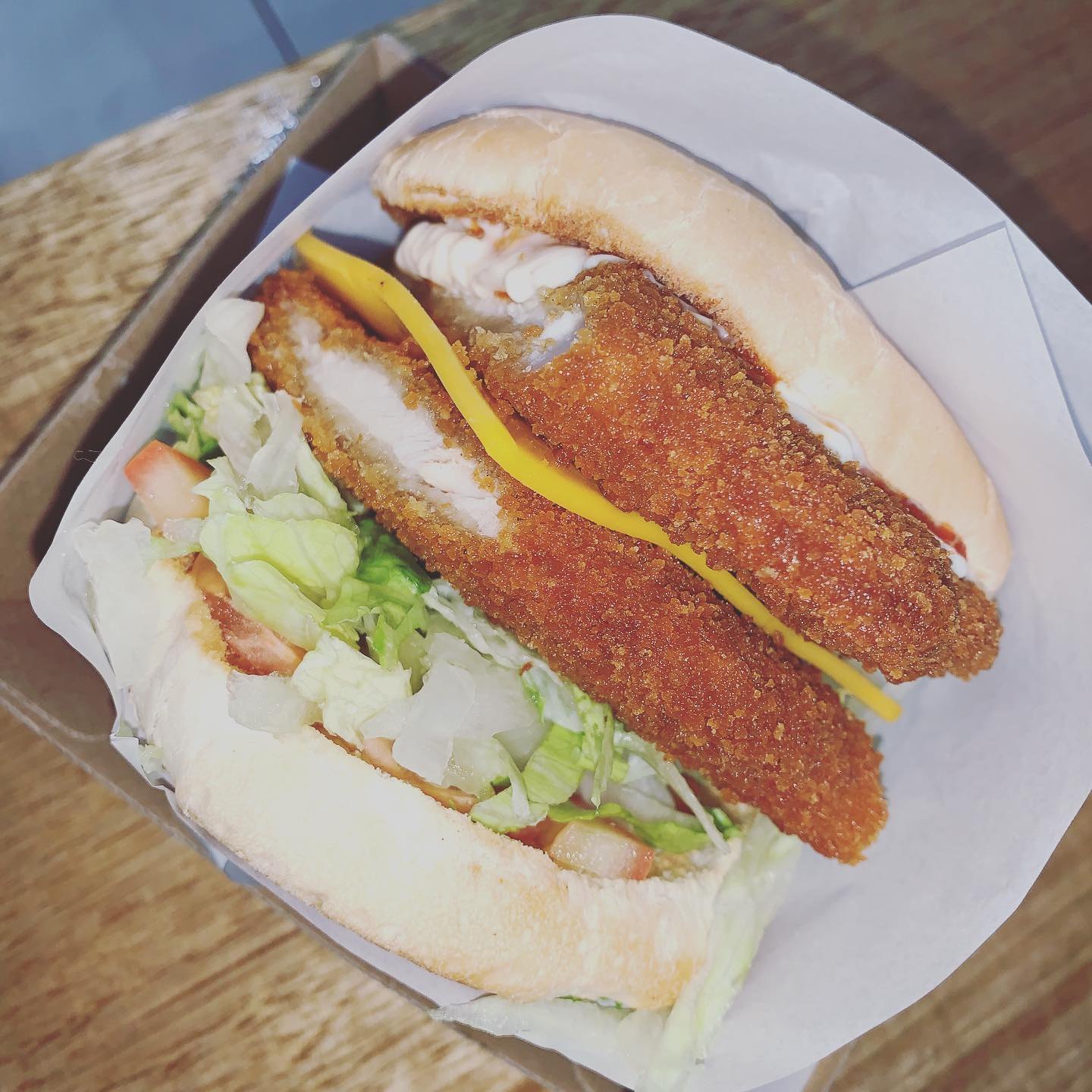 Crumbed fish burger with cheese and salad